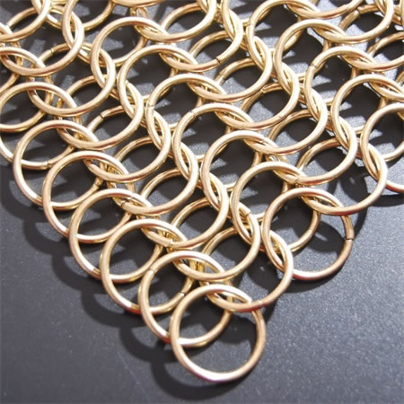 Corner of a piece of ring mesh made of brass wire.