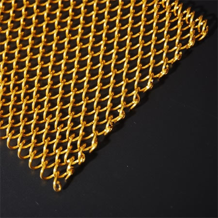 A piece of spiral wire mesh made of brass on the black ground.