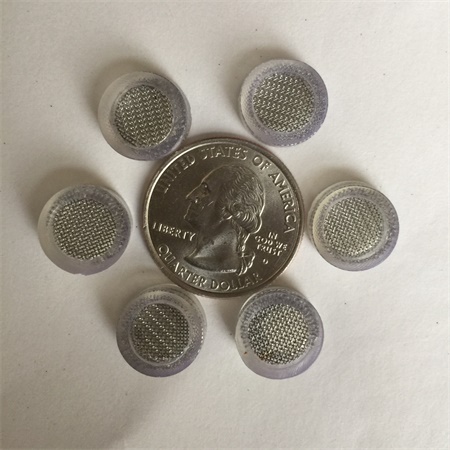 Six screen gaskets are around a foreign coin.