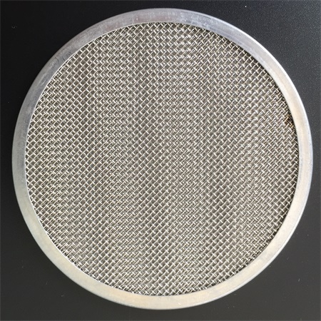 A piece of multi-layer mesh disc with metal frame on the black ground.