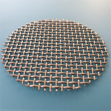 A piece of stainless steel mesh disc on the blue ground.