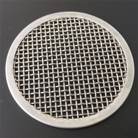 A stainless steel wire mesh disc with metal frame on the black ground.