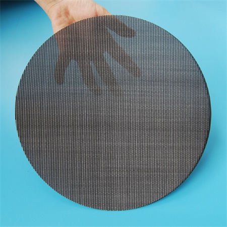 A hand is holding a piece of twilled weave mesh disc.